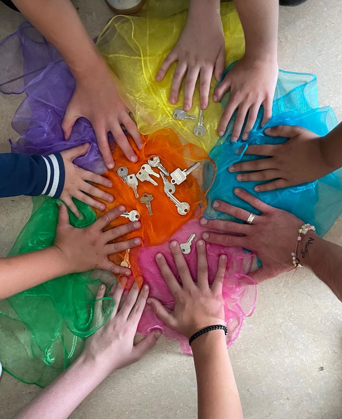 Kinderhände auf bunten Tüchern bei einer Achtsamkeitsübung in der Schule